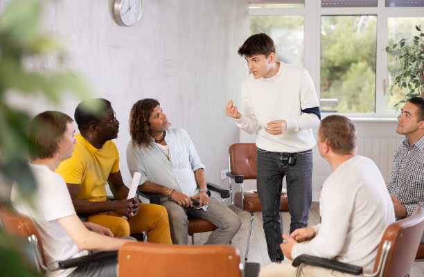 和男同事聊天的人聚集在办公室休息室图片下载