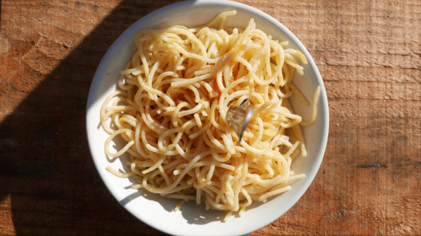 面食盘隔离。午餐盘，俯视图，特写:桌上的培根意大利面。培根意大利面。橄榄油意大利面。吃面条。吃意大利面条。桌面视图。在阳光下的午餐桌图片下载