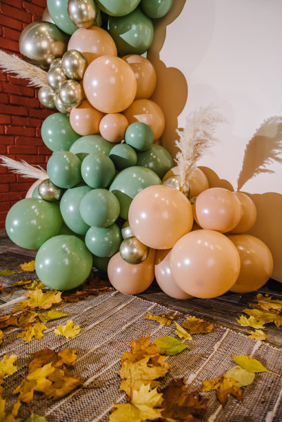 细节时髦的秋季装饰。拱门上装饰着绿色、棕色、金色的气球、干树叶，用于婚礼仪式。生日宴会的接待。庆祝洗礼。照片墙装饰文字空间。前图片下载