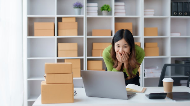 亚洲女性小企业主，对成功的笔记本电脑感到高兴。兴奋的成功。亚洲女商人举手示意。图片下载