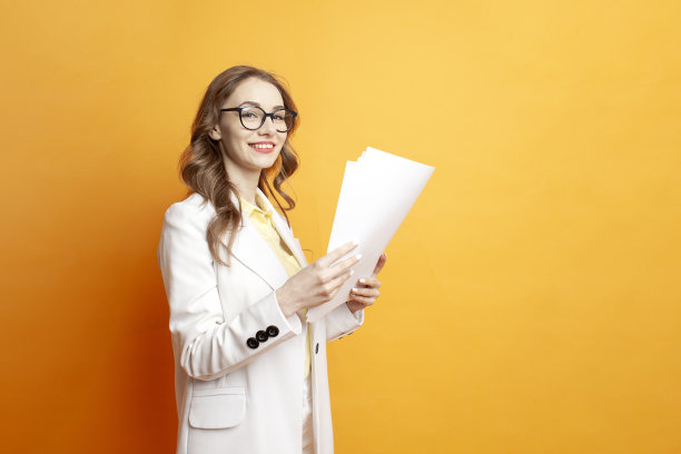 穿着白色西装的女商人拿着橙色背景的文件，戴眼镜的女经理拿着文件图片下载