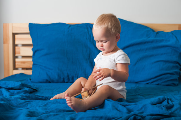 幼童在床上玩飞机(特写)。图片下载