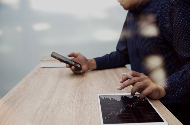 商务人士用数码平板电脑在办公桌上处理商务文件图片下载