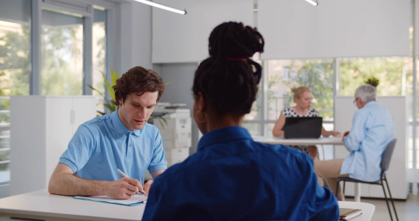 非洲女商人将剪贴板递给客户签署协议的背影图片下载