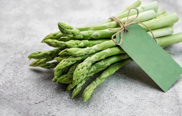 混凝土背景上的新鲜绿芦笋。图片下载