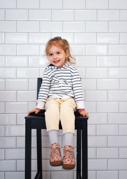 一个微笑的女孩坐在椅子上的肖像图片下载