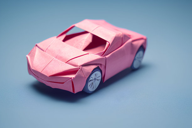 迷你粉色模型折纸车显示在一个明亮的蓝色表面图片下载