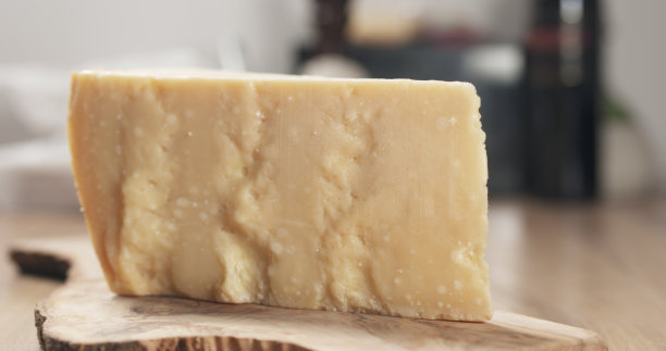 一块硬帕尔马干酪放在橄榄板上图片下载