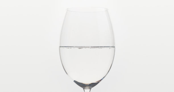 把水倒进白色背景的酒杯里图片下载