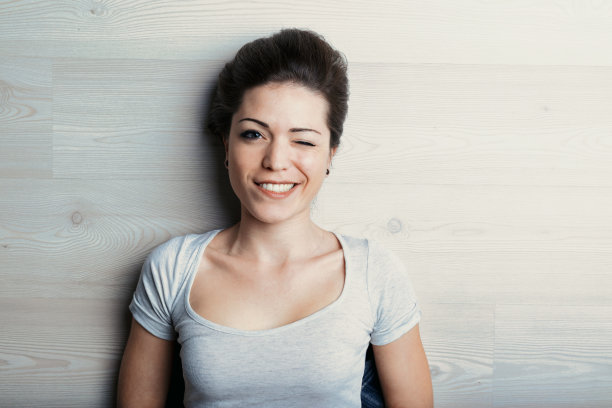 短发女人微笑着，眨眨眼图片下载