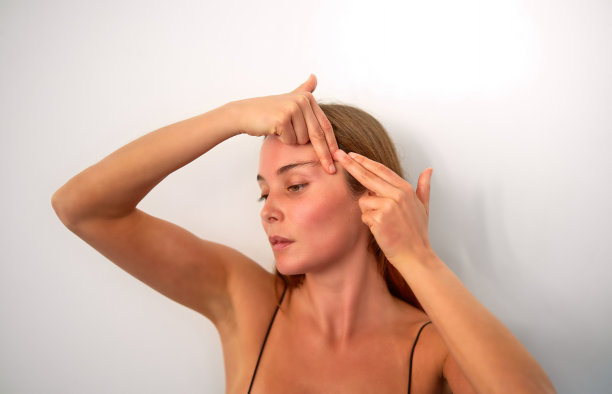 年轻的白人女性在工作室练习面部瑜伽图片下载