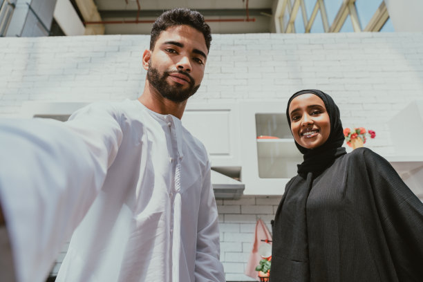 快乐的中东夫妇在家中穿着传统的阿拉伯服装图片下载