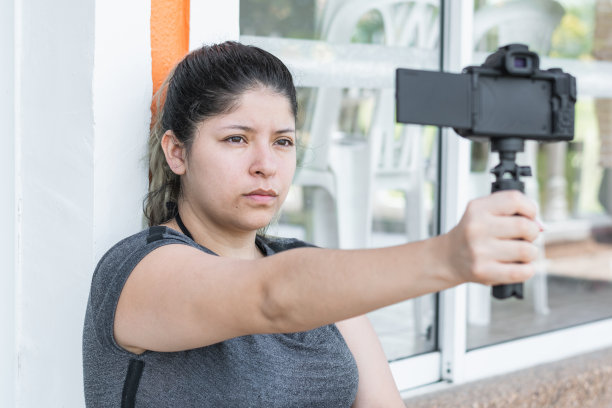 拿着相机写博客的拉丁女孩，看起来很严肃图片下载