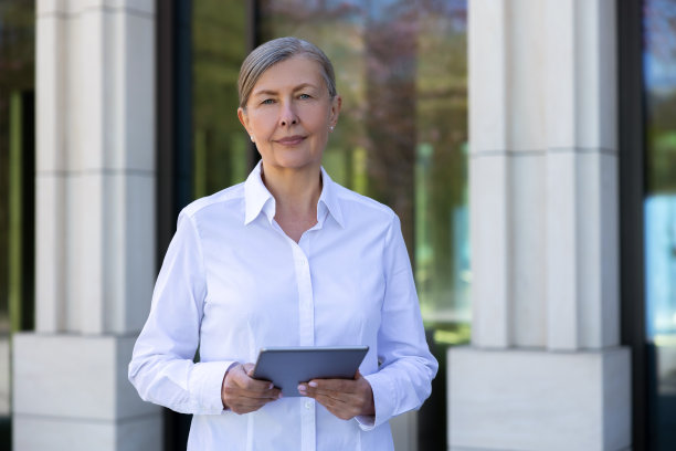 穿着白衬衫，手里拿着笔记本电脑的女商人图片下载