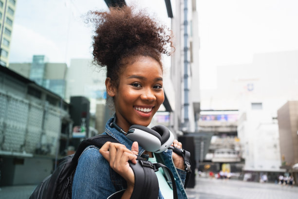 一个快乐的女人背着背包走在城市的街上图片下载