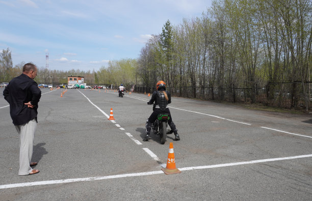 一位年轻女子在摩托车学校学习骑摩托车。她由一位老师教图片下载