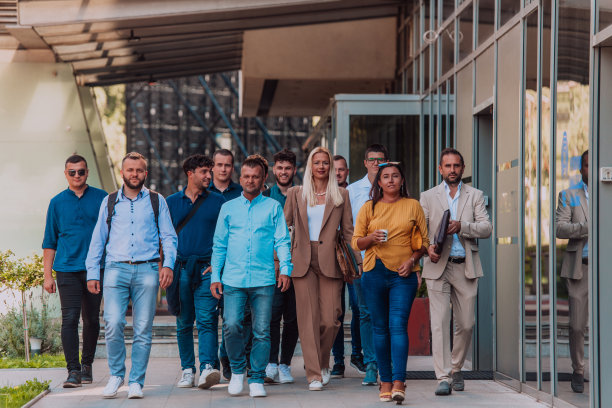 一群不同的商人和同事一起走过他们的工作场所，展示公司的协作和团队精神。图片下载