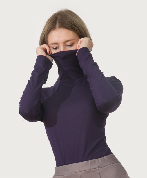 年轻女模特穿着紫色有机棉高领毛衣的工作室摄影。舒适的可持续时尚图片下载