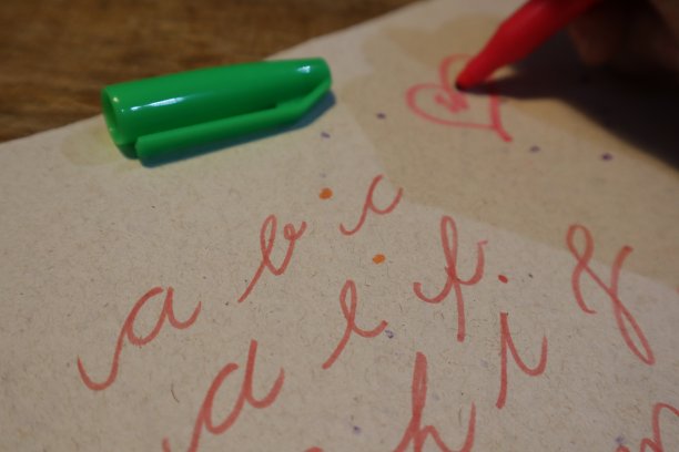 用彩色笔在纸上写字母的人图片下载