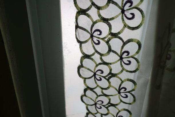 窗前有透明颜色和花卉图案的窗帘图片下载