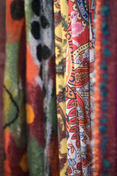 不同颜色图案的羊毛梭织织物以红色调居多，挂在商店、复制空间出售，重点选择图片下载