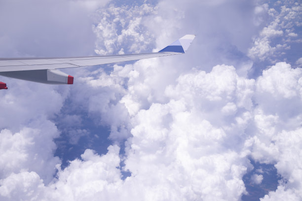 飞机的翅膀在明亮的蓝天上飞过云层图片下载