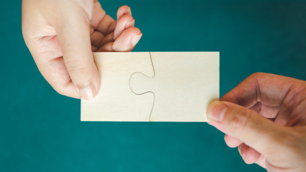 夫妻一家人手握空白和空白的拼图。人与休闲的理念。伙伴关系和友谊主题。图片下载