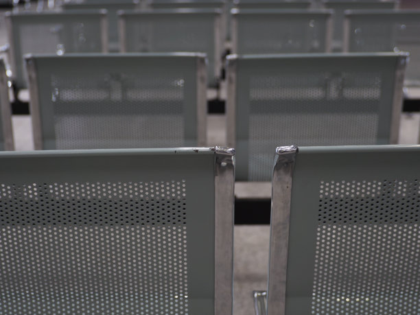 铁椅子，黄白色的灯光，灰黑色的天花板。图片下载