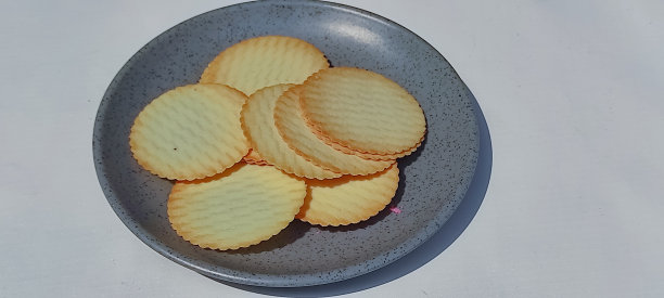 圆盐饼干，圆饼干孤立的白色背景，干饼干孤立，零食和快餐的概念，土豆饼干或去土豆，盐土豆饼干上的盘子图片下载