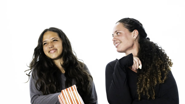 可爱的拉丁裔母女在电影院分享爆米花，背景是白色的图片下载