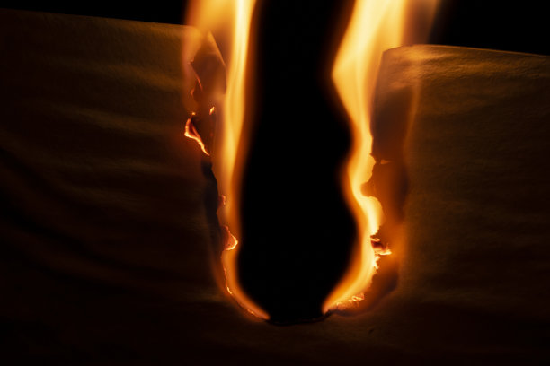 燃烧的纸，在黑色背景上发光的纸边图片下载