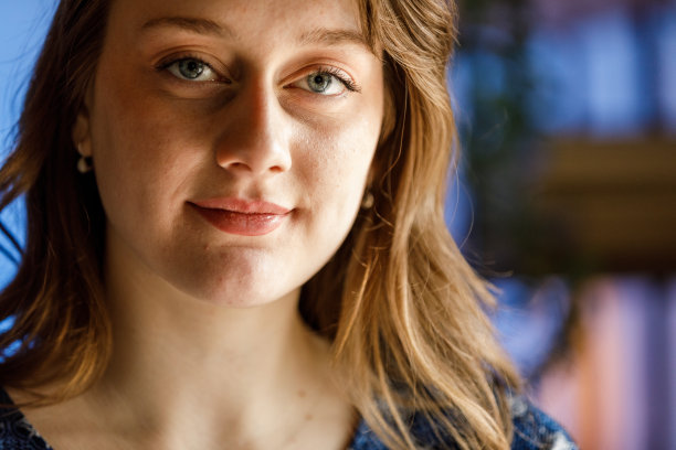 年轻迷人的蓝眼睛女人看着镜头，微笑着图片下载