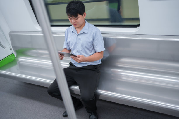 男子在地铁车厢里使用平板电脑图片下载