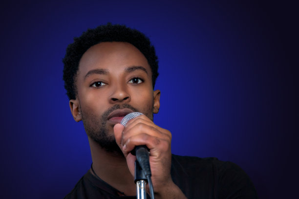 摇滚歌手拿着麦克风在蓝色背景的派对卡拉ok表演图片下载