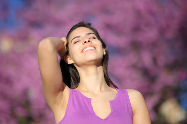 在紫罗兰公园里微笑的快乐女人图片下载