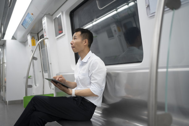 亚洲男子在地铁上使用平板电脑图片下载