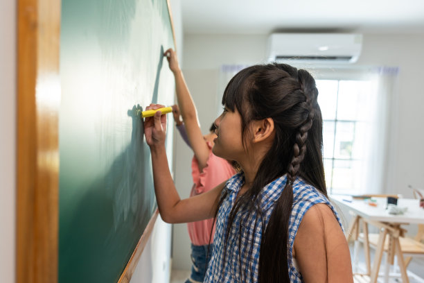 小学生在教室里写黑板。可爱的小朋友们在室内做着有趣的活动，在船上画着可爱的卡通，一起在幼儿园快乐地玩耍。图片下载
