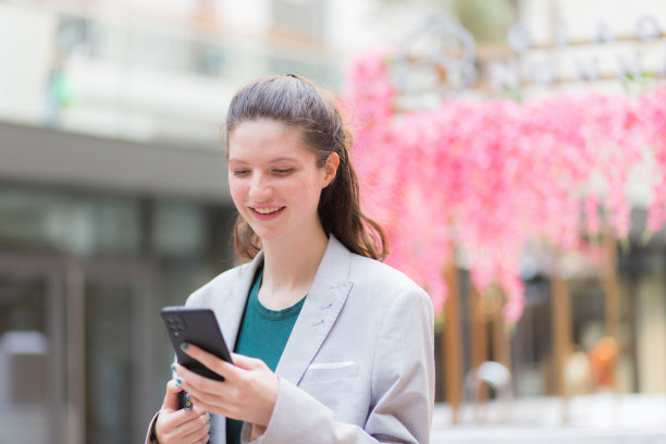 年轻女子用手机在镇上走来走去图片下载
