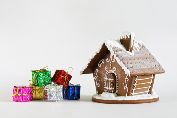 姜饼屋和圣诞新年礼物装在白色背景的彩色盒子里。副本的空间。设计空白的圣诞快乐和新年快乐贺卡。图片下载