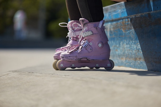 在一个滑板公园里，穿着时髦的直排溜冰鞋的滑冰女孩。年轻的女子在夏天滑旱冰图片下载