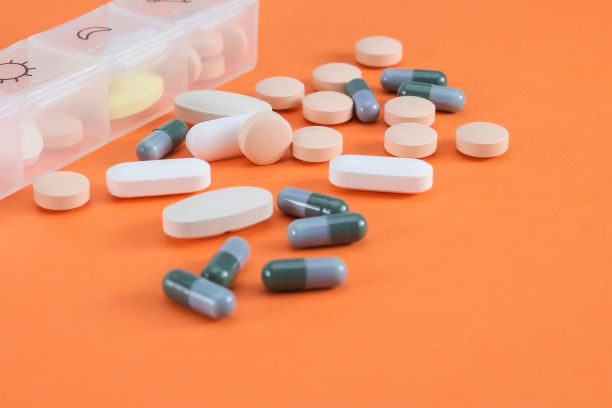 橙色背景上排列的药片的特写图片下载