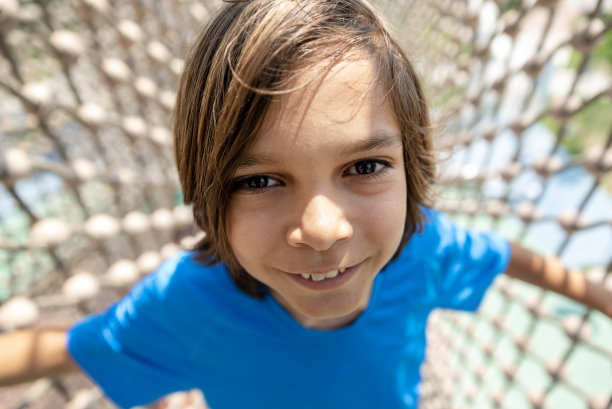 小男孩在户外免费公共冒险公园的绳索课程图片下载