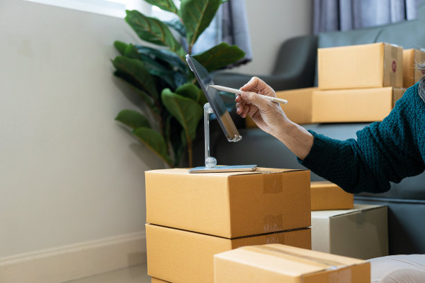 网上商店妇女拿着包裹电子商务包装邮政运输箱订单检查网上零售商店在仓库送货服务中小企业的经营理念图片下载