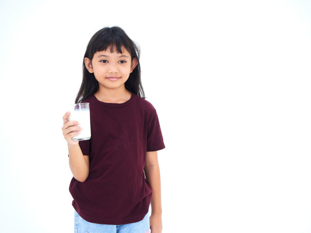 小女孩拿着一杯白色背景的牛奶图片下载