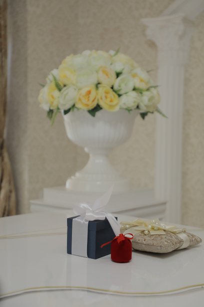 照片上金色的结婚戒指上从婚礼花束上摘下的白玫瑰图片下载