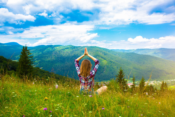 在山上做瑜伽。美丽的女孩正在做体式冥想。令人惊叹的夏季大自然。和谐与旅游理念。潮人旅行。享受生活的时尚女性。图片下载