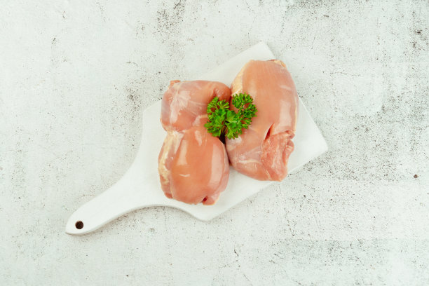 新鲜生无皮鸡大腿肉与新鲜香草在灰色背景。副本的空间。有机食品，健康饮食。食品的概念。前视图。零售食品。图片下载