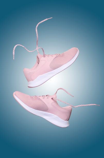 带鞋带的粉色女性运动鞋漂浮在蓝色背景上图片下载