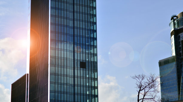 抬头看市中心的商业大厦。蓝天映衬下的现代办公楼。图片下载