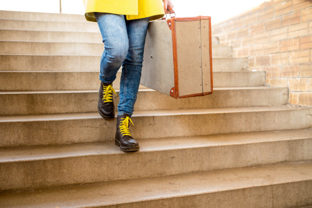 游客提着行李箱穿过车站等火车图片下载